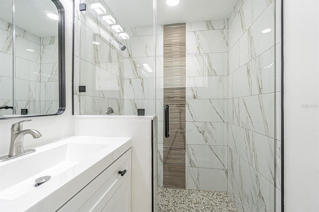 5631 Riddle Road Holiday, FL 34690 - Photo 18 of 27 a bathroom with a sink and a shower