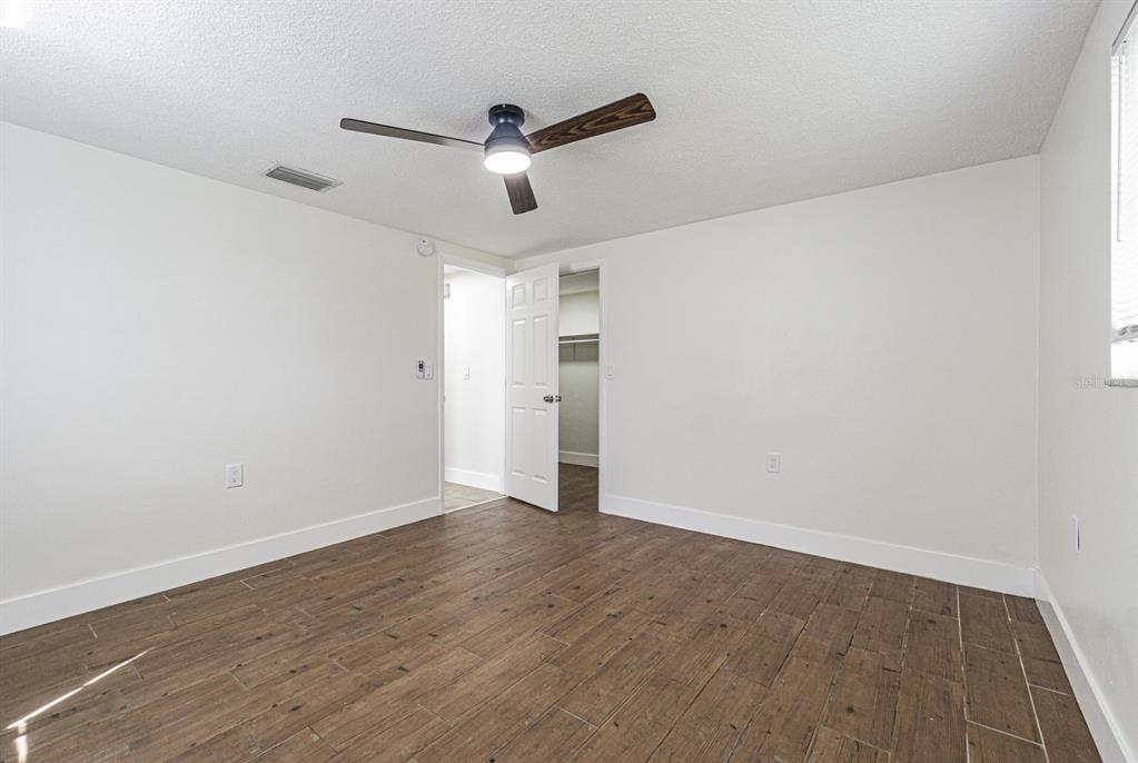 5631 Riddle Road Holiday, FL 34690 - Photo 20 of 27 an empty room with wooden floor ceiling fan and window