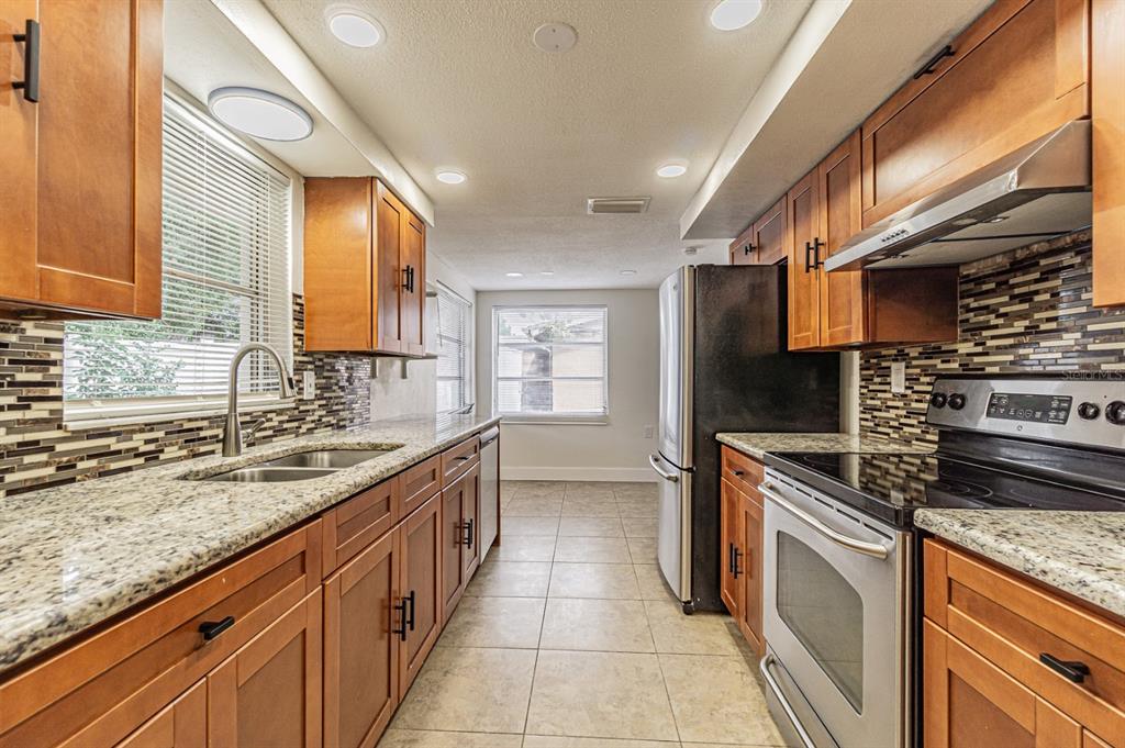 5631 Riddle Road Holiday, FL 34690 - Photo 6 of 27 a kitchen with stainless steel appliances granite countertop a sink and a stove