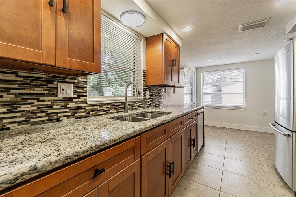 5631 Riddle Road Holiday, FL 34690 - Photo 8 of 27 a kitchen with granite countertop a sink a stove and cabinets