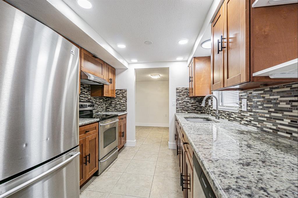 5631 Riddle Road Holiday, FL 34690 - Photo 10 of 27 a kitchen with a sink stove and refrigerator
