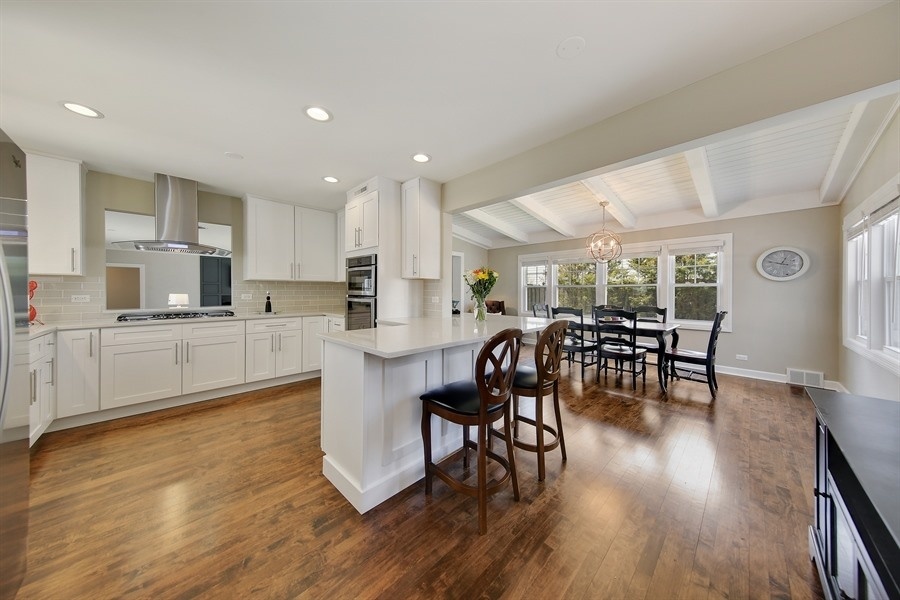 906 South County Line Road Hinsdale, IL 60521 - Photo 9 of 44 a kitchen with a table chairs wooden floors and white stainless steel appliances
