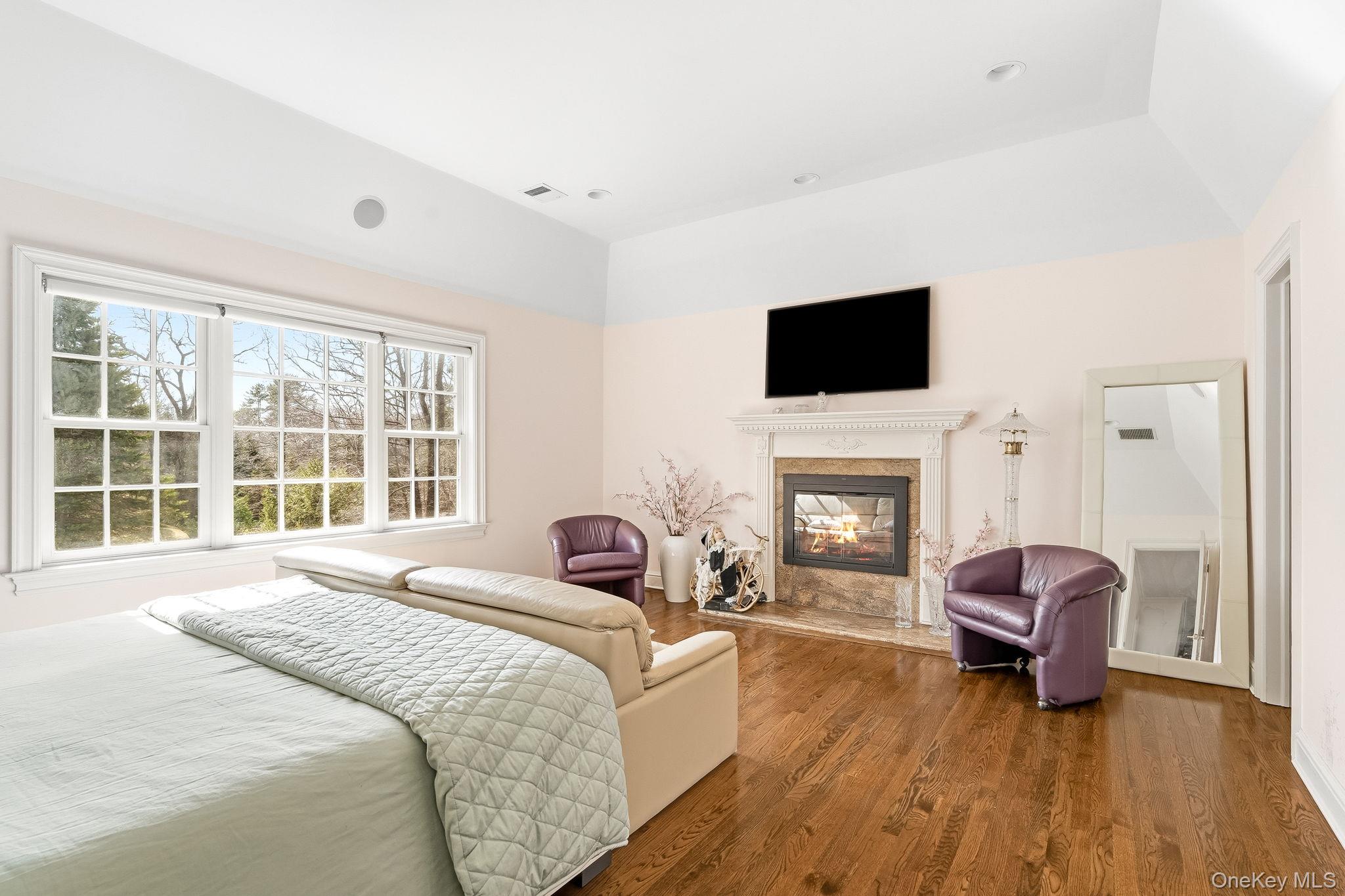 58 Old Logging Road Bedford, NY 10506 - Photo 20 of 34 a spacious bedroom with a bed and a fireplace