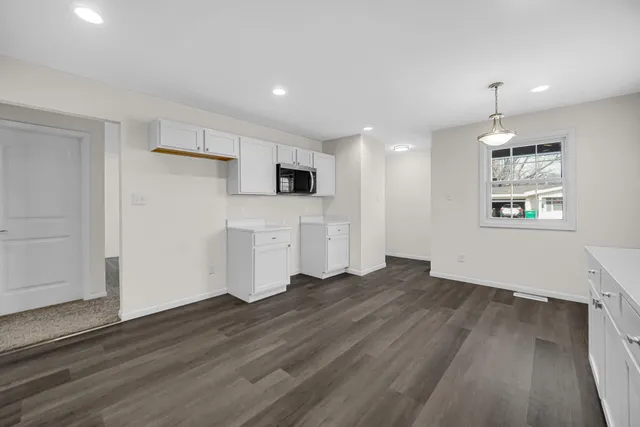 a view of empty room with wooden floor and window