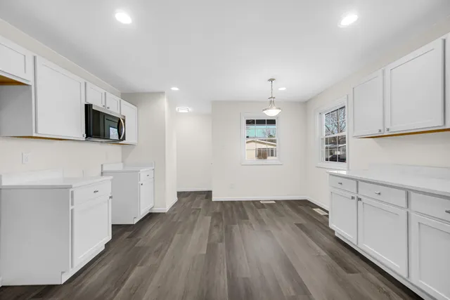 a kitchen with cabinets a window and stainless steel appliances