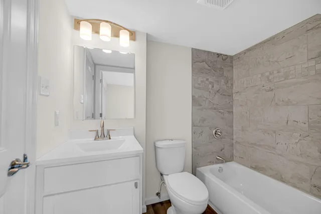 a bathroom with a sink a toilet and shower