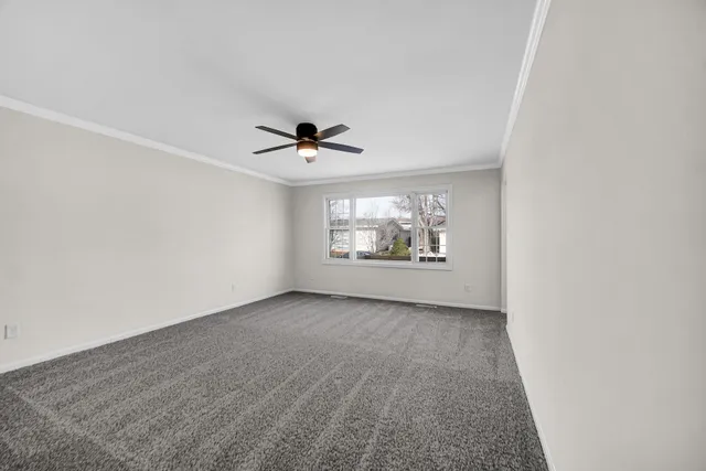 an empty room with window and ceiling fan