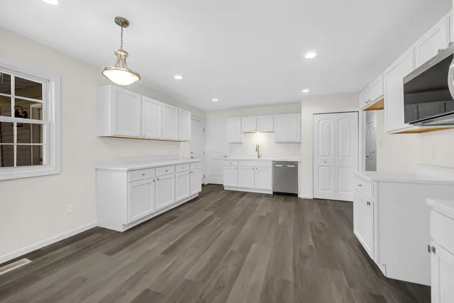 a kitchen with white cabinets and stainless steel appliances