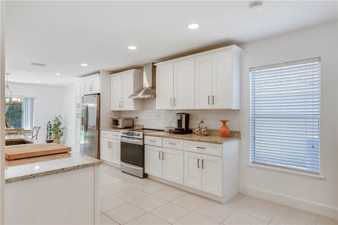 402 Lexington Avenue Southwest Vero Beach, FL 32962 - Photo 11 of 33 a kitchen with granite countertop white cabinets and white appliances