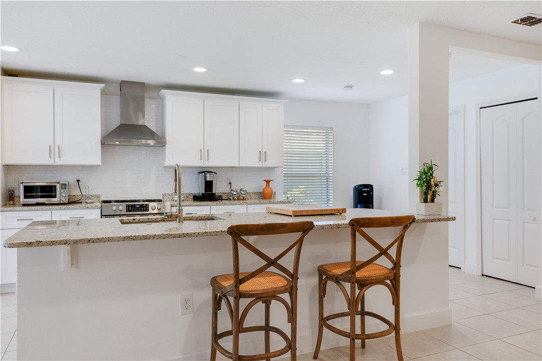402 Lexington Avenue Southwest Vero Beach, FL 32962 - Photo 13 of 33 a kitchen with stainless steel appliances granite countertop a table and chairs in it