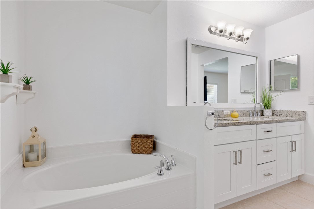 402 Lexington Avenue Southwest Vero Beach, FL 32962 - Photo 19 of 33 a bathroom with a bathtub sink and mirror