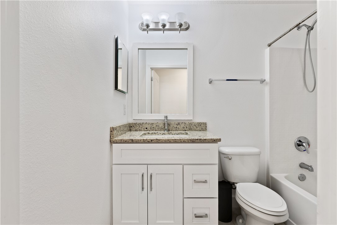 402 Lexington Avenue Southwest Vero Beach, FL 32962 - Photo 22 of 33 a bathroom with a granite countertop sink toilet a mirror and shower