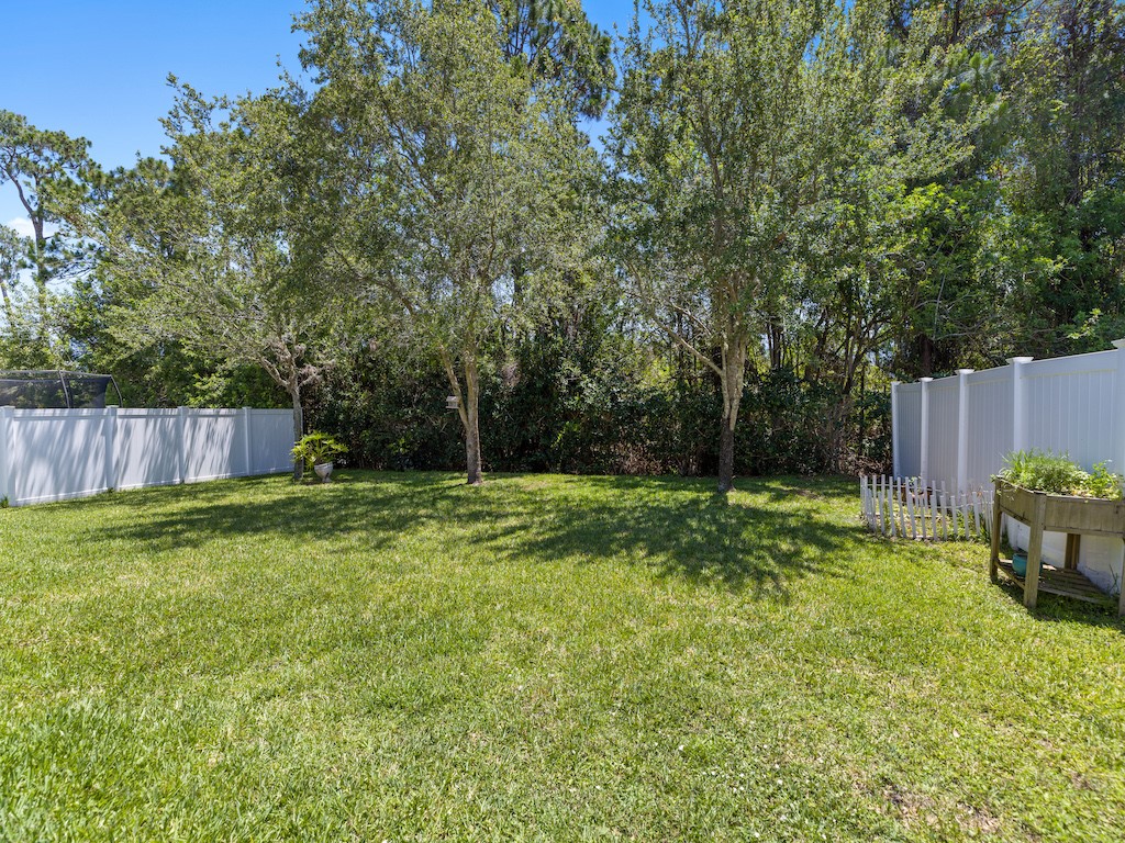 402 Lexington Avenue Southwest Vero Beach, FL 32962 - Photo 26 of 33 a view of backyard with table and chairs and wooden fence