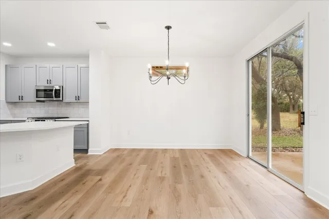 a view of a kitchen with wooden floor and electronic appliances