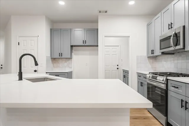 a kitchen with stainless steel appliances granite countertop a white stove top oven and white cabinets