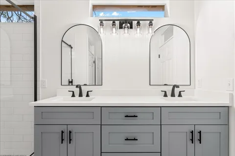 a bathroom with a double vanity sink and a mirror