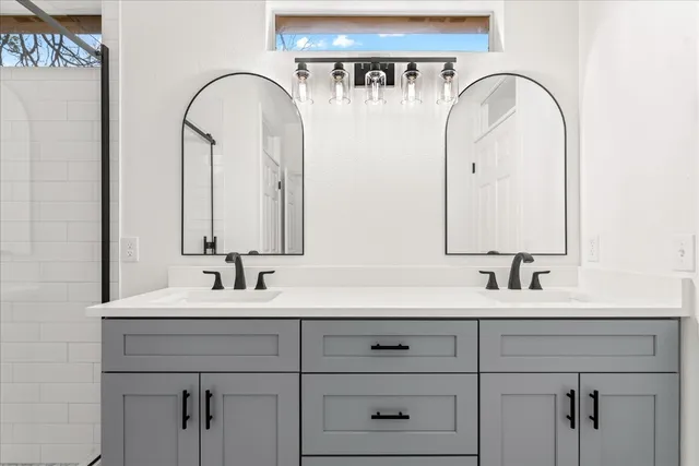 a bathroom with a double vanity sink and a mirror