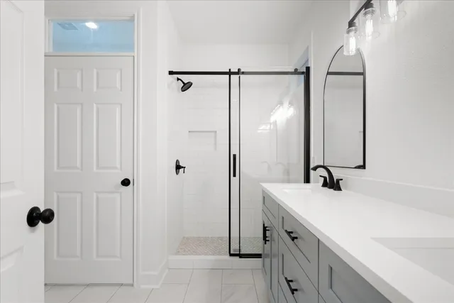 a bathroom with a double vanity sink mirror and shower