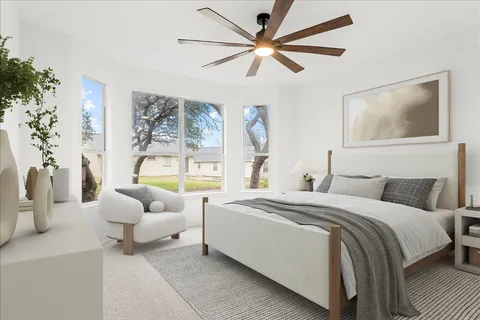 a bedroom with a large bed couch and a large window