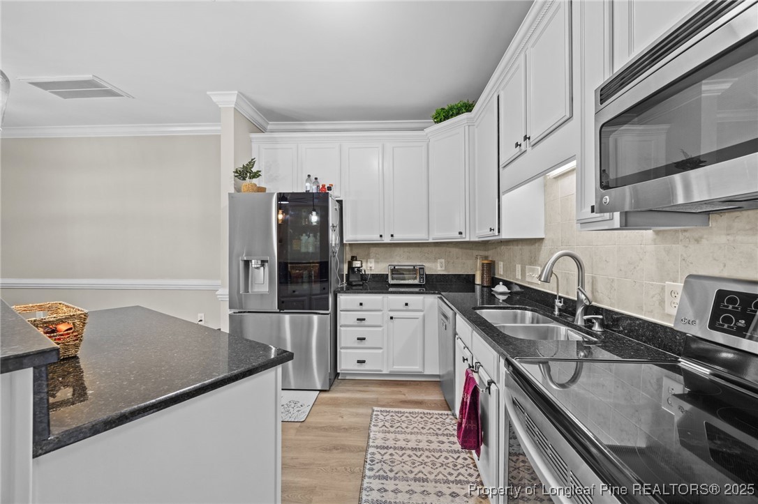62 Gallery Drive, Unit 302 Spring Lake, NC 28390 - Photo 11 of 34 a kitchen with stainless steel appliances granite countertop a sink stove and refrigerator