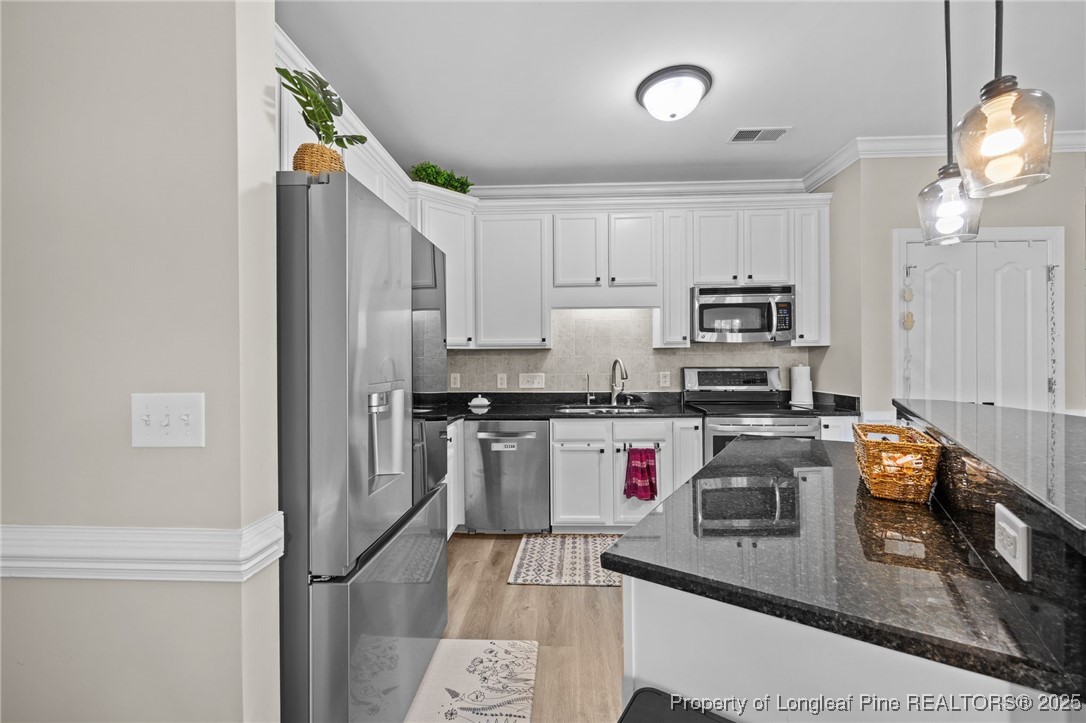 62 Gallery Drive, Unit 302 Spring Lake, NC 28390 - Photo 13 of 34 a kitchen with kitchen island granite countertop a sink cabinets and stainless steel appliances