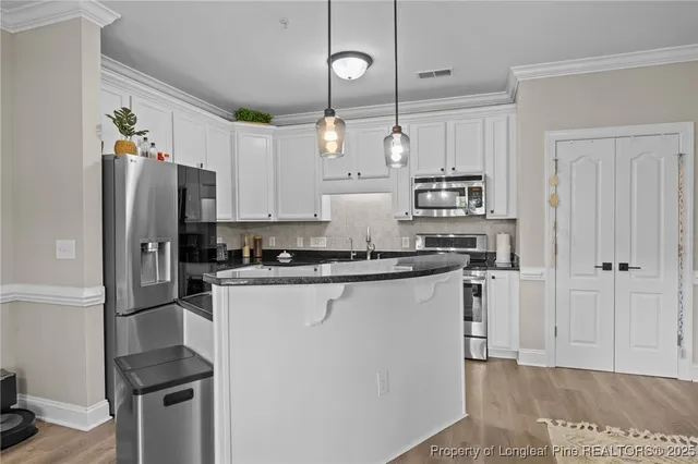 a kitchen with stainless steel appliances a refrigerator sink and stove