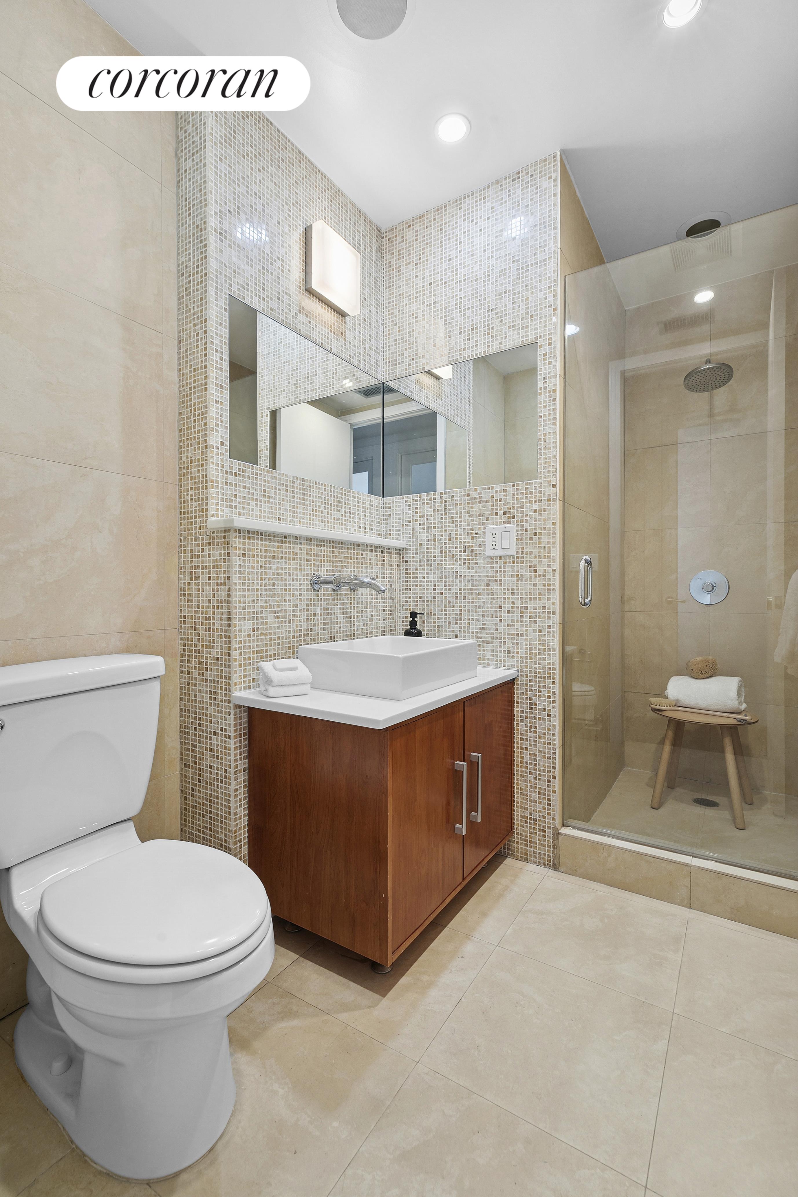 46 Lispenard Street, Unit 5E Manhattan, NY 10013 - Photo 7 of 8 a spacious bathroom with a sink a toilet and a mirror