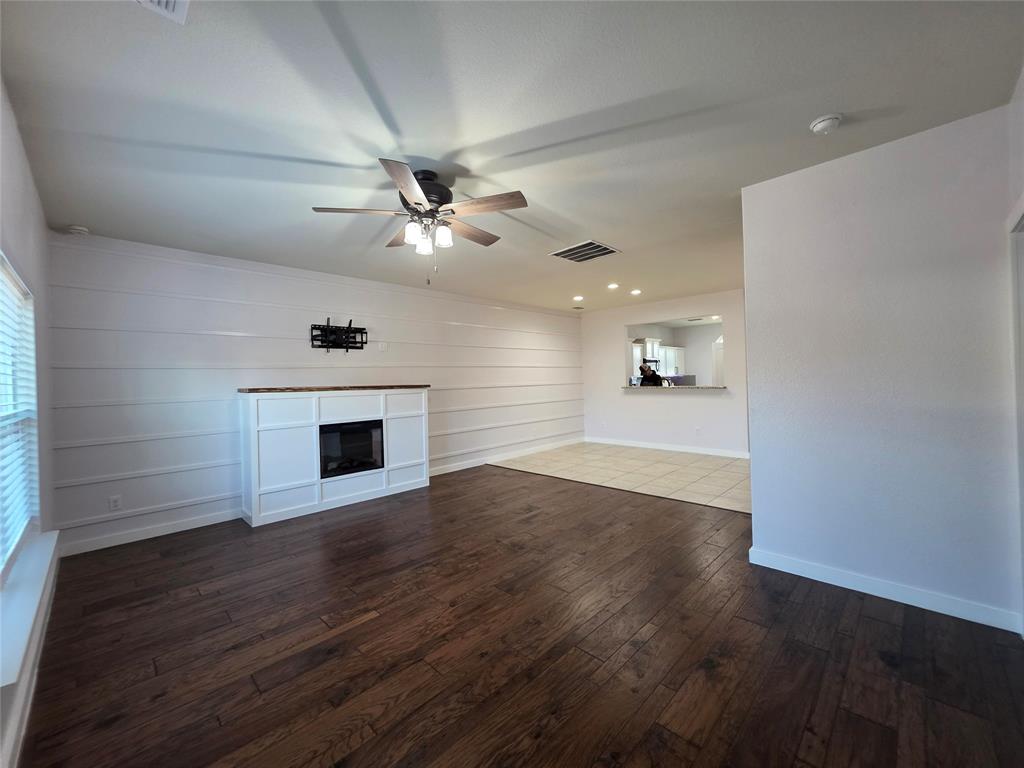 149 Ryan Street Anna, TX 75409 - Photo 7 of 38 a view of an empty room with wooden floor and a fireplace