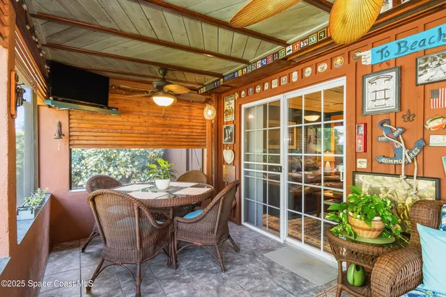 a view of a dining room with furniture and potted plants