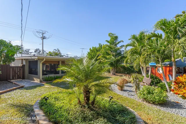 a view of a house with backyard and tree