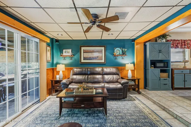 a living room with furniture a ceiling fan and a rug