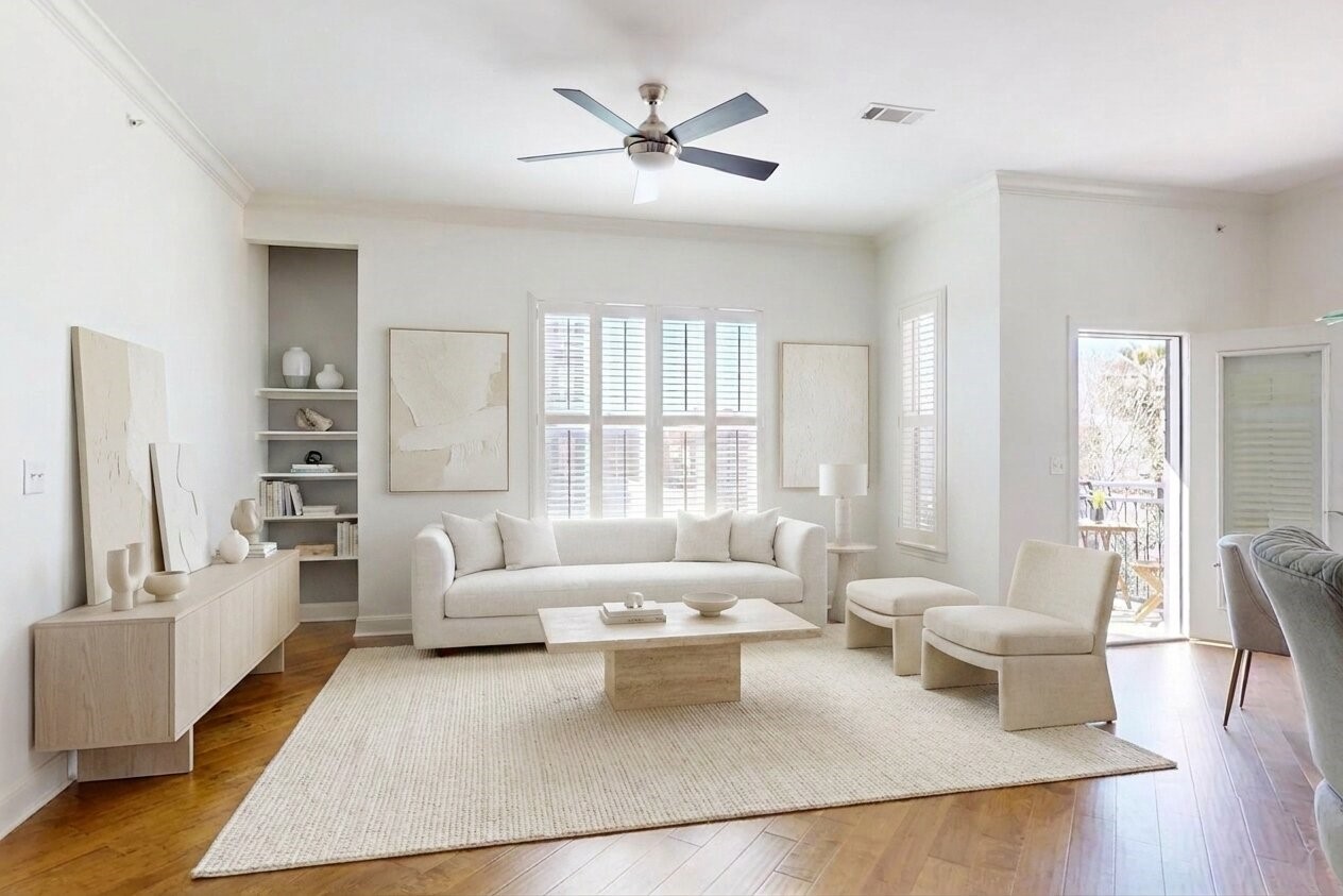 1010 Rosine Street, Unit 29 Houston, TX 77019 - Photo 4 of 16 Bright, modern living room featuring a neutral color palette with a plush sofa, armchairs, and a sleek coffee table. The space is enhanced by natural light from large windows and an open door leading to a balcony. (Virtual Staging)