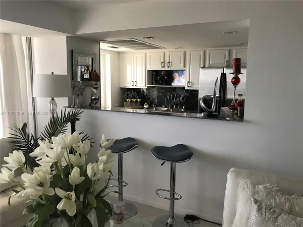 a view of kitchen with stainless steel appliances kitchen island granite countertop a refrigerator and microwave