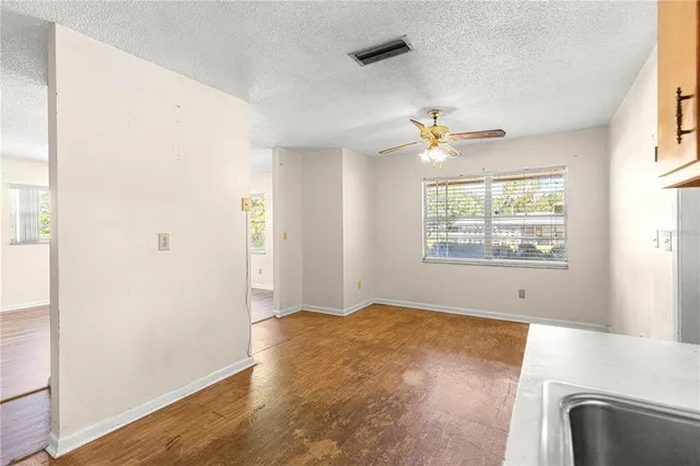 an empty room with windows and fan