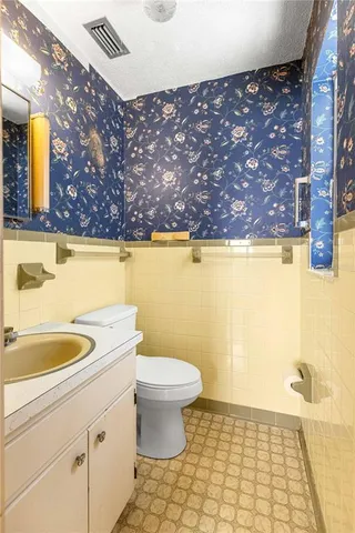 a bathroom with a sink a toilet and mirror