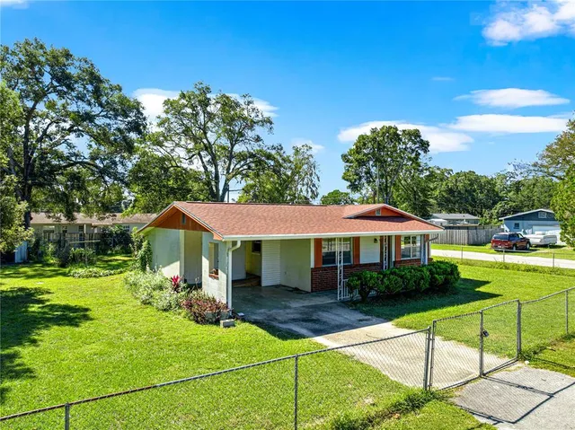 a view of a white house with a yard table and chairs