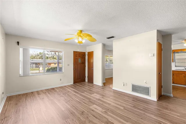 an empty room with window and wooden floor