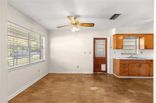 a view of an empty room with window and cabinet
