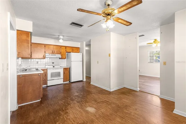 a view of kitchen with stainless steel appliances cabinets and wooden floor