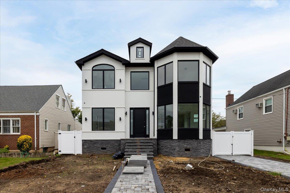 Modern home featuring a gate, crawl space, and stucco siding