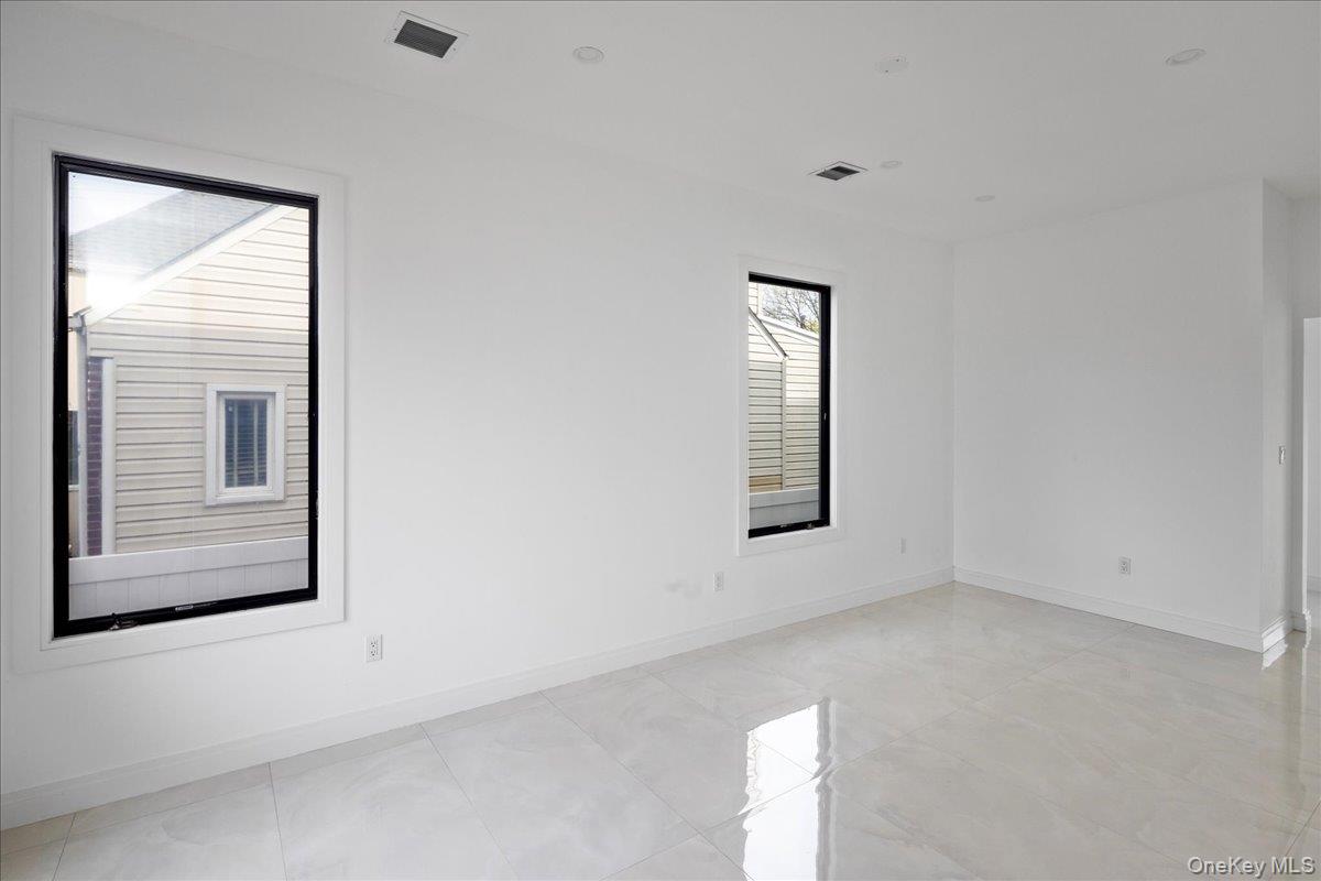 544 Arlington Road Cedarhurst, NY 11516 - Photo 11 of 38 an empty room with windows