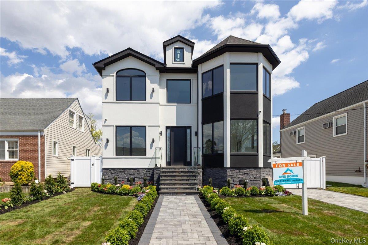 544 Arlington Road Cedarhurst, NY 11516 - Photo 2 of 38 a front view of a house with garden