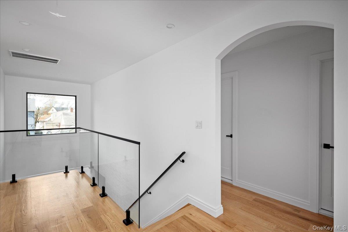 544 Arlington Road Cedarhurst, NY 11516 - Photo 22 of 38 a view of a hallway with wooden floor and stairs