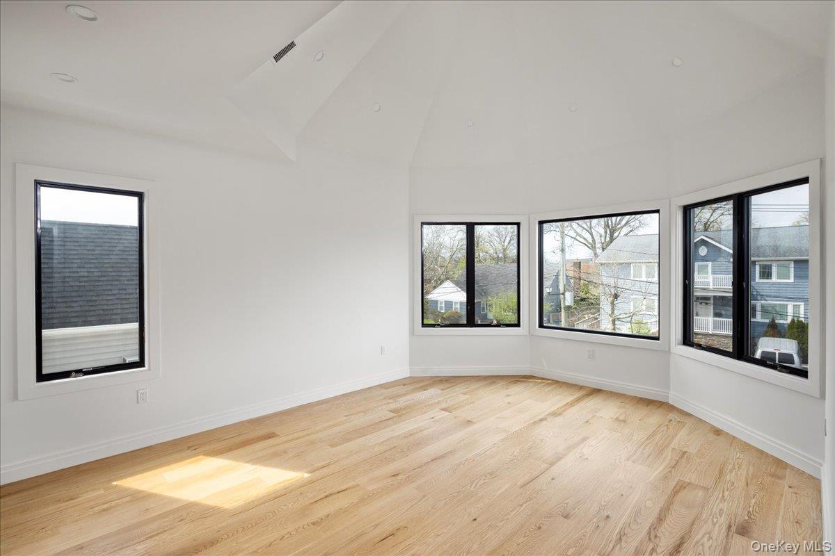 544 Arlington Road Cedarhurst, NY 11516 - Photo 23 of 38 an empty room with wooden floor and windows