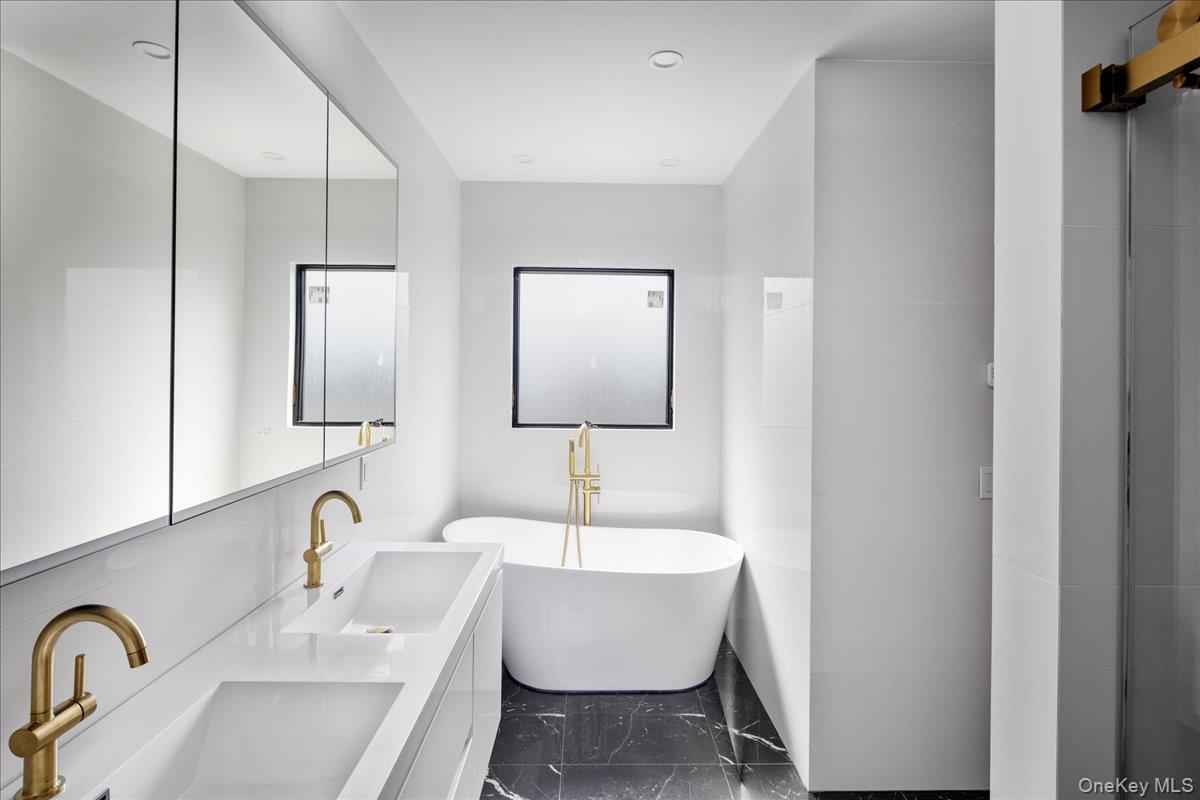 544 Arlington Road Cedarhurst, NY 11516 - Photo 25 of 38 a bathroom with a double vanity sink and mirror