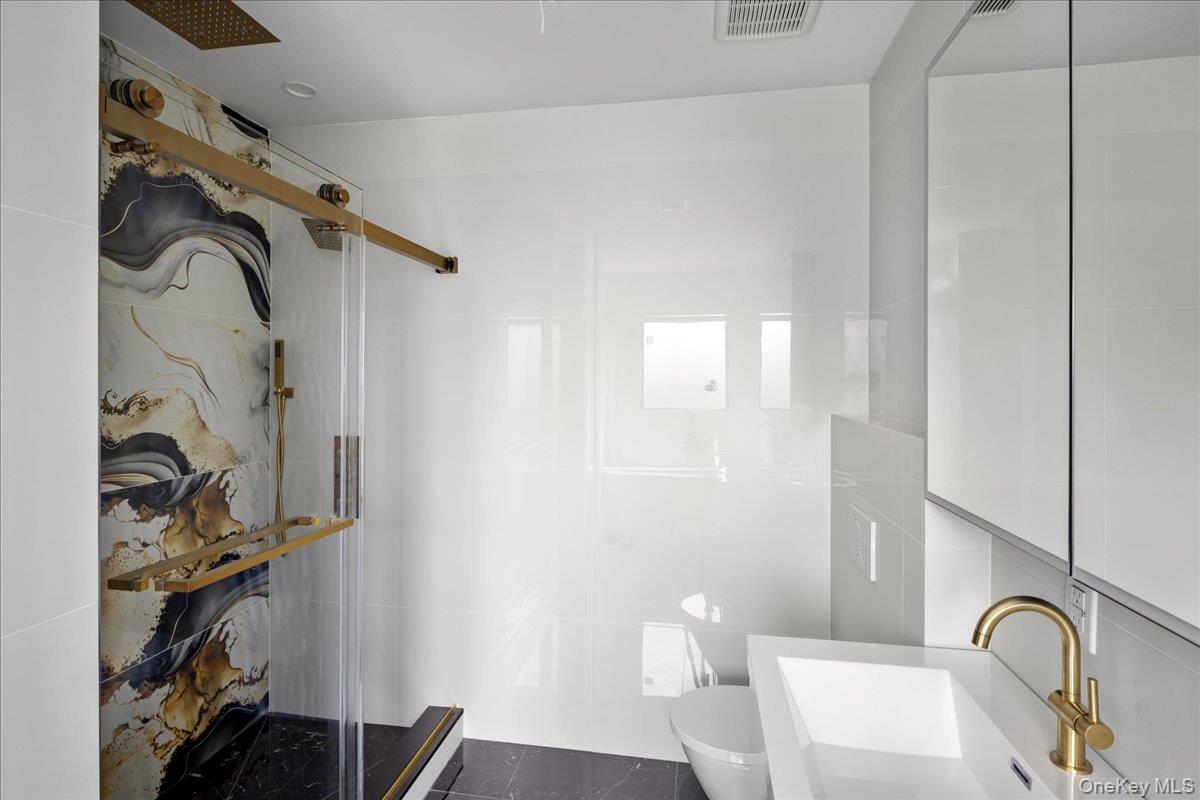 544 Arlington Road Cedarhurst, NY 11516 - Photo 26 of 38 a bathroom with a bathtub and shower