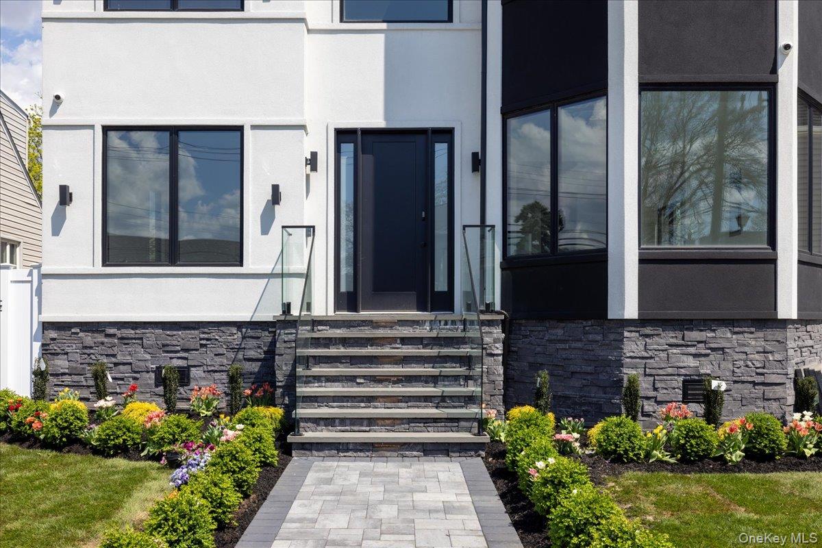 544 Arlington Road Cedarhurst, NY 11516 - Photo 3 of 38 a front view of a house with a garden