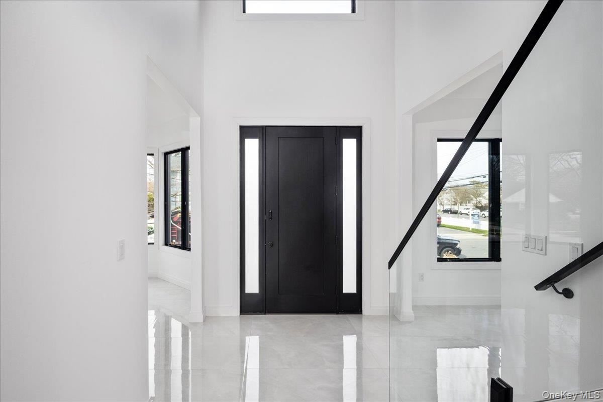 544 Arlington Road Cedarhurst, NY 11516 - Photo 4 of 38 a view of staircase with white walls and a window