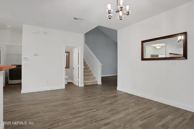 a view of a livingroom with wooden floor and a ceiling fan