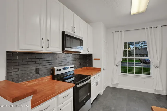 a kitchen with stainless steel appliances granite countertop a sink and a microwave